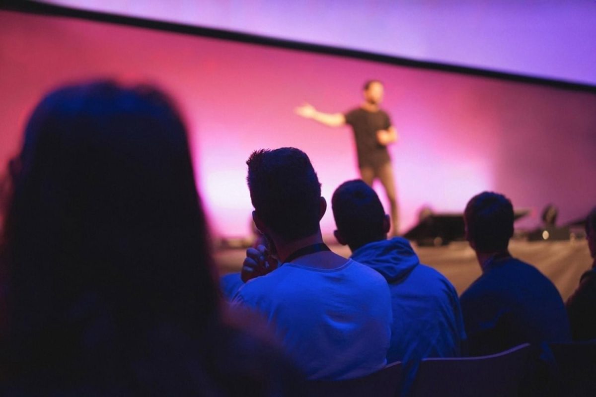 Audience watching a speaker on a large interactive LED wall at a UAE conference