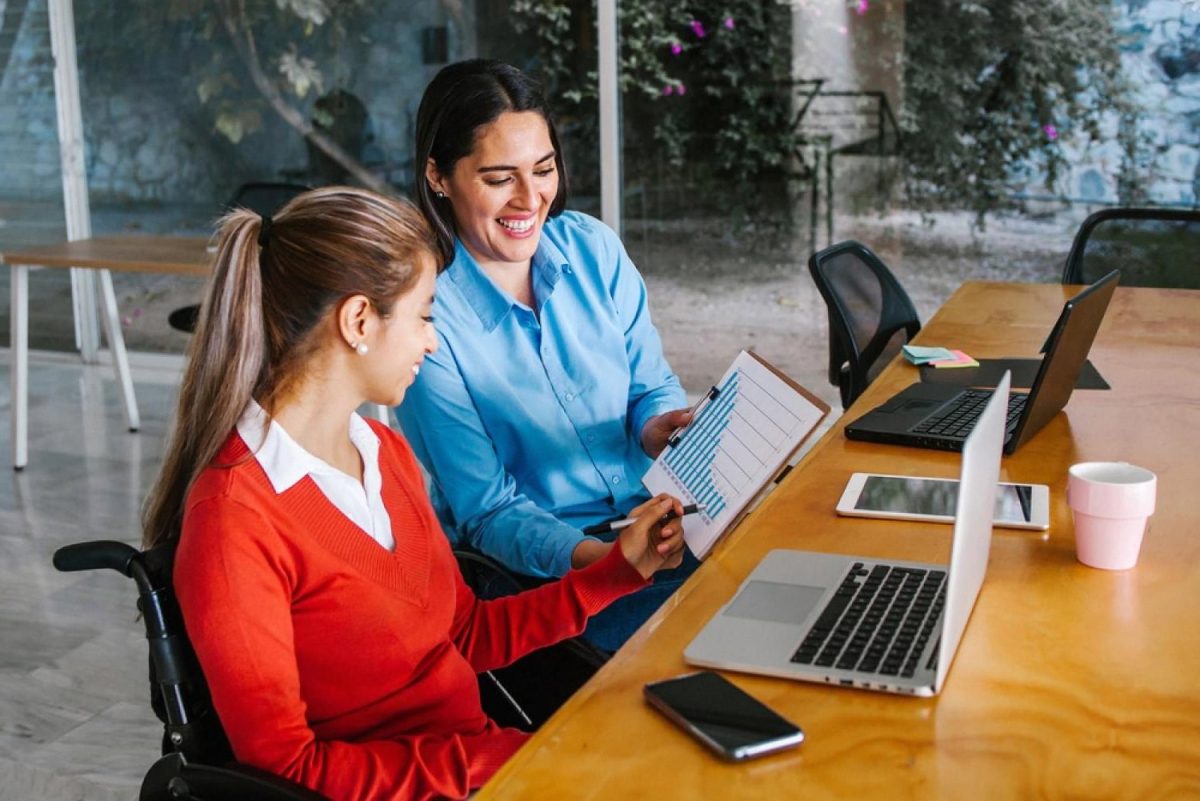 Two HR colleagues reviewing a flexible working policy together in a UAE office