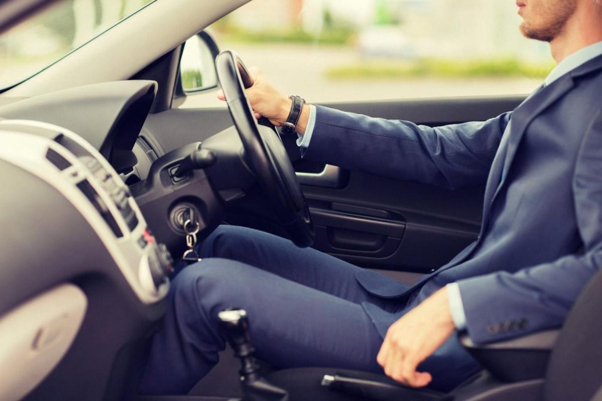 Chauffeur in a blue suit driving a client through Dubai as part of a monthly chauffeur service